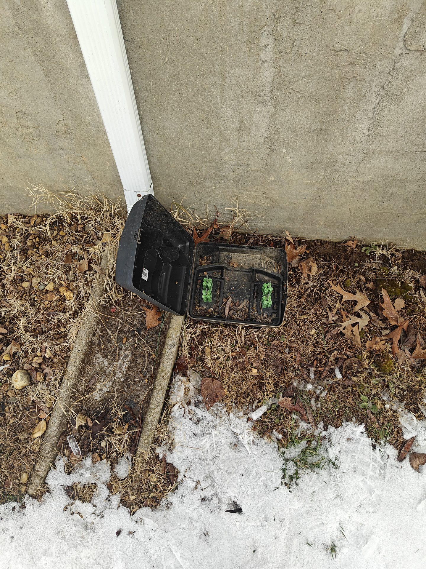 Rodent bait station installed at a building corner