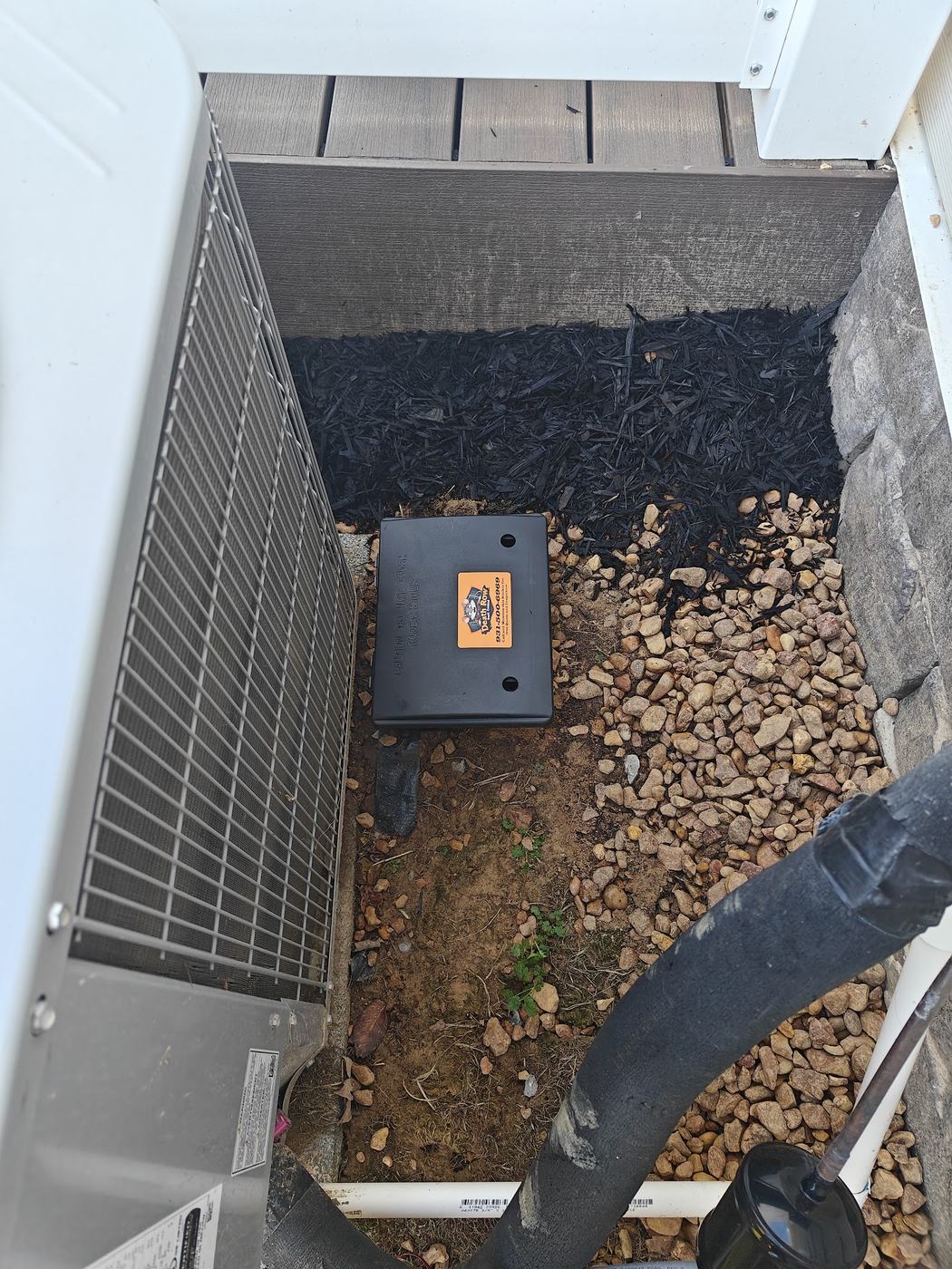 Tamper-resistant rodent bait station beside an outdoor AC unit in Spring Hill TN